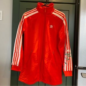 Adidas track jacket with embroidered flowers and quote.